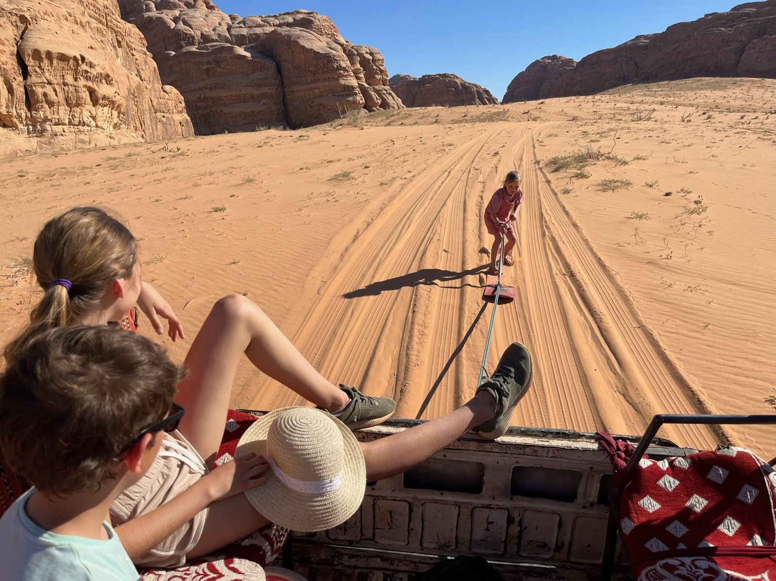Enfant faisant du sandboard sur une dune de Wadi Rum