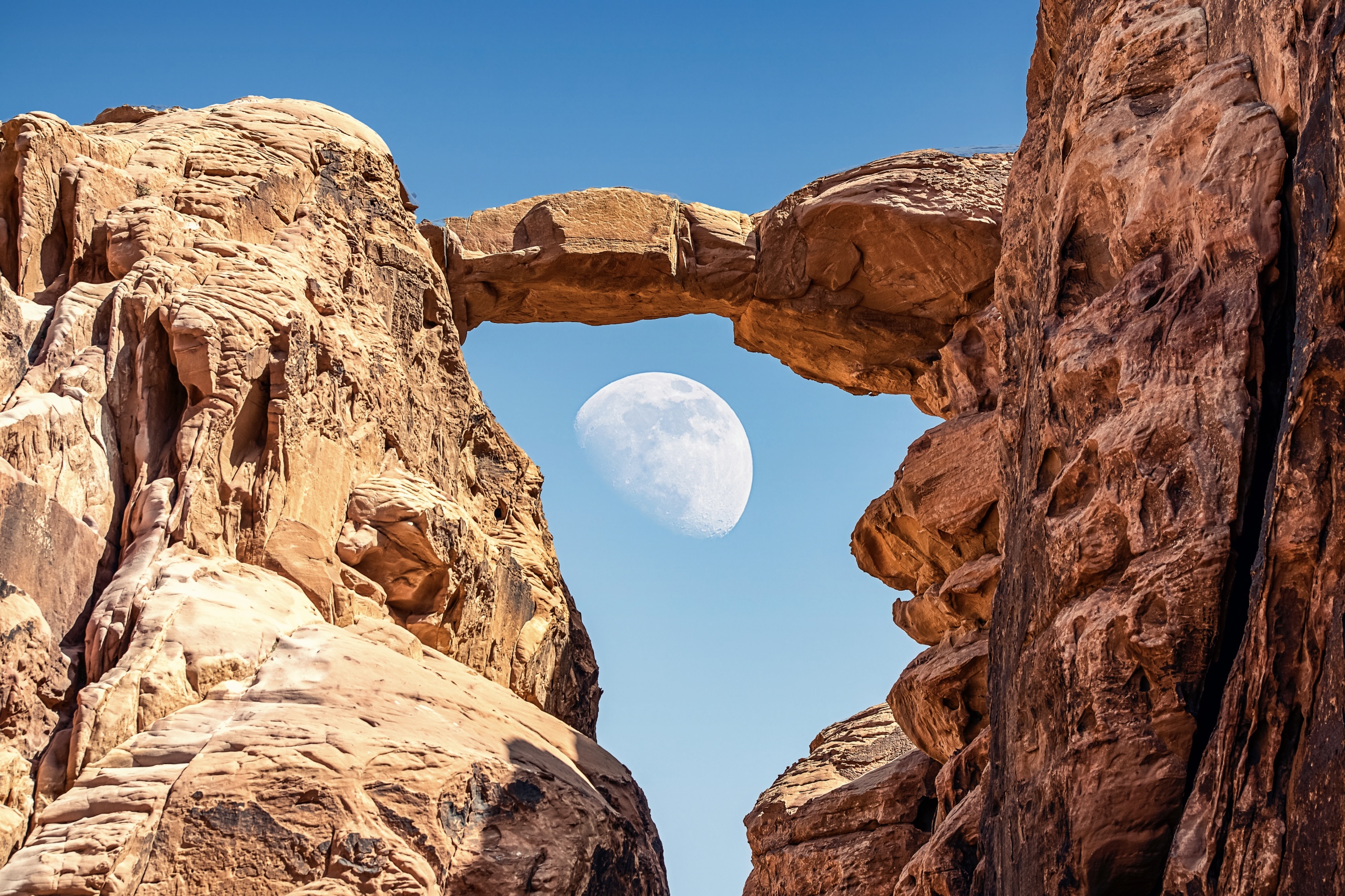 Group under Burdah rock bridge at sunset in Wadi Rum
