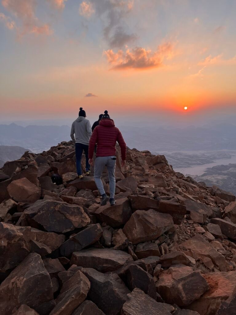 Randonneurs sur la crête d’Umm ad Dami au coucher du soleil