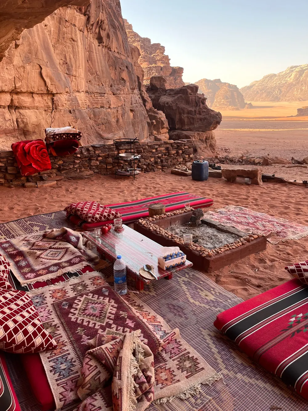 Camp cushions and rugs at the foot of a cliff in Wadi Rum