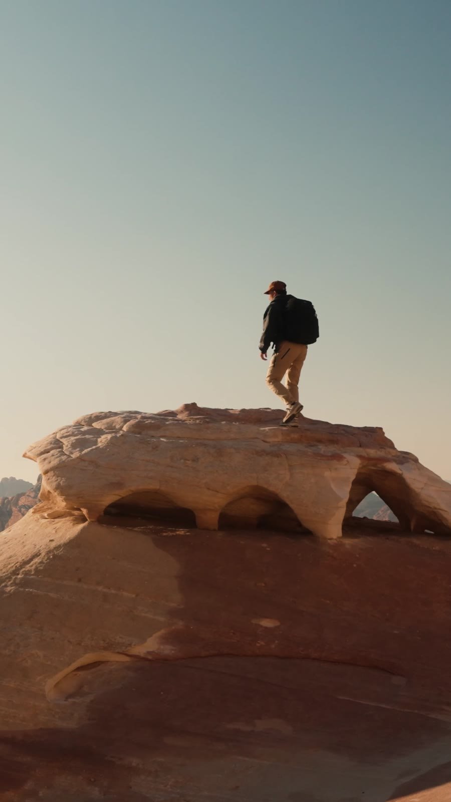 Randonneur au sommet d'un pont rocheux à Wadi Rum