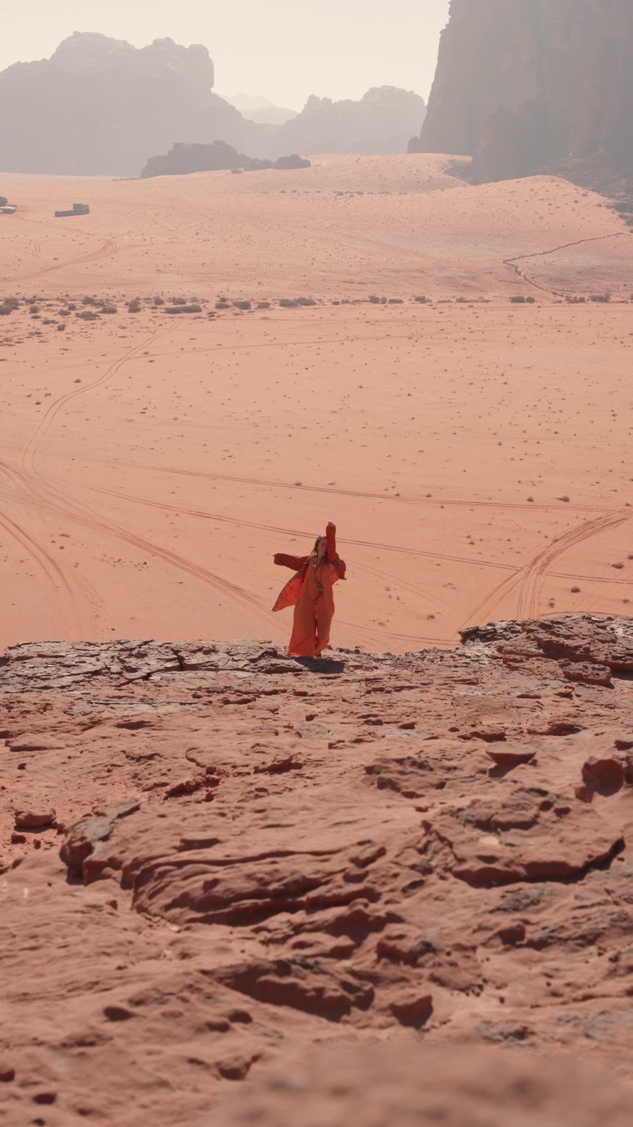 Voyageuse en robe rouge sur les rochers de Wadi Rum