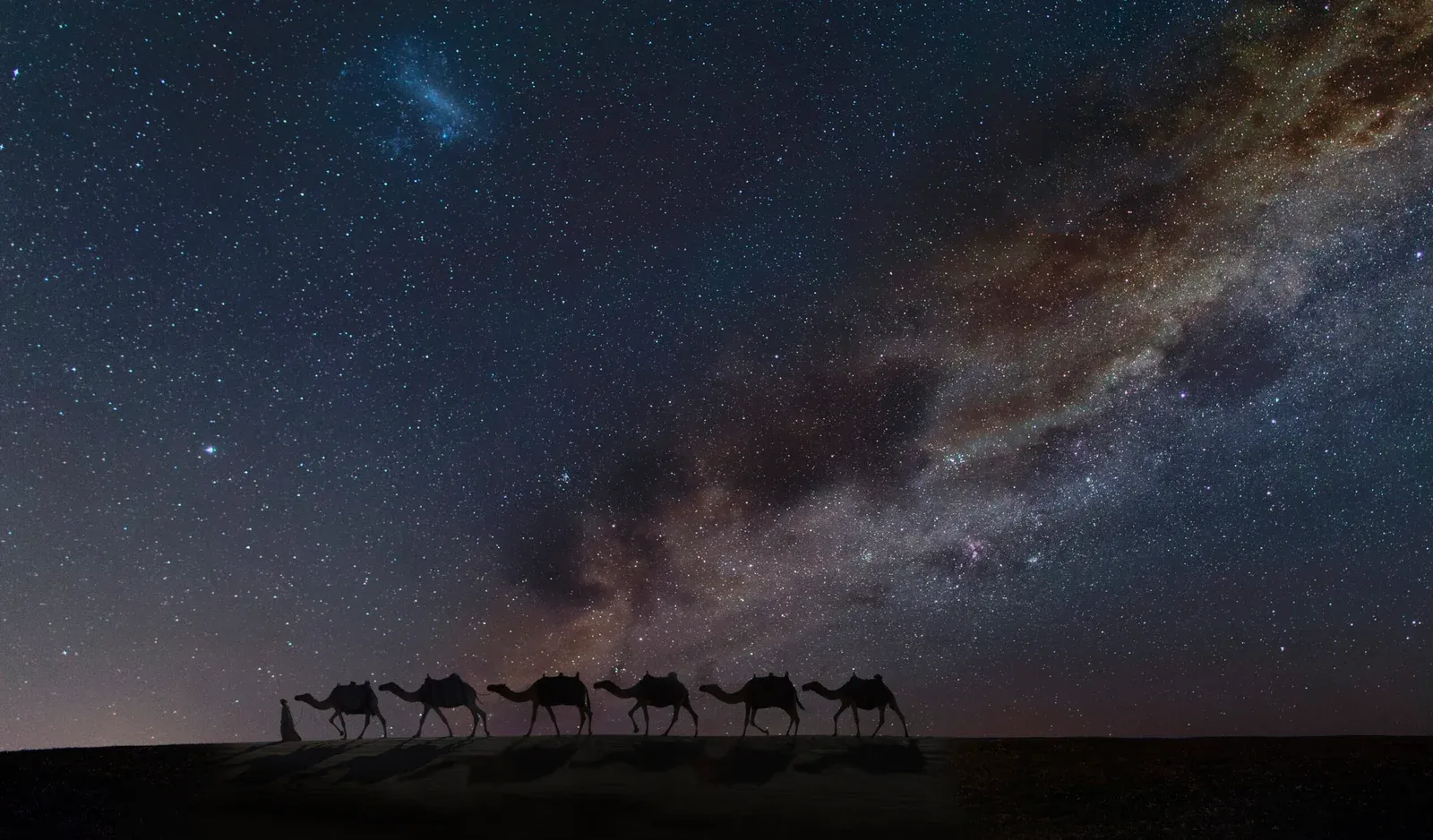 Chameaux traversant le désert sous les étoiles